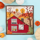 Quilt with a red barn design surrounded by pumpkins on a light blue background