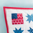 Quilt with star and flag patterns on a light blue background
