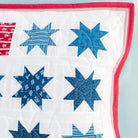 Quilt with blue star patterns on a white background