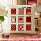 Decorative pillow with red fabric swatches and 'Life is Sew Good' text on a wooden surface.