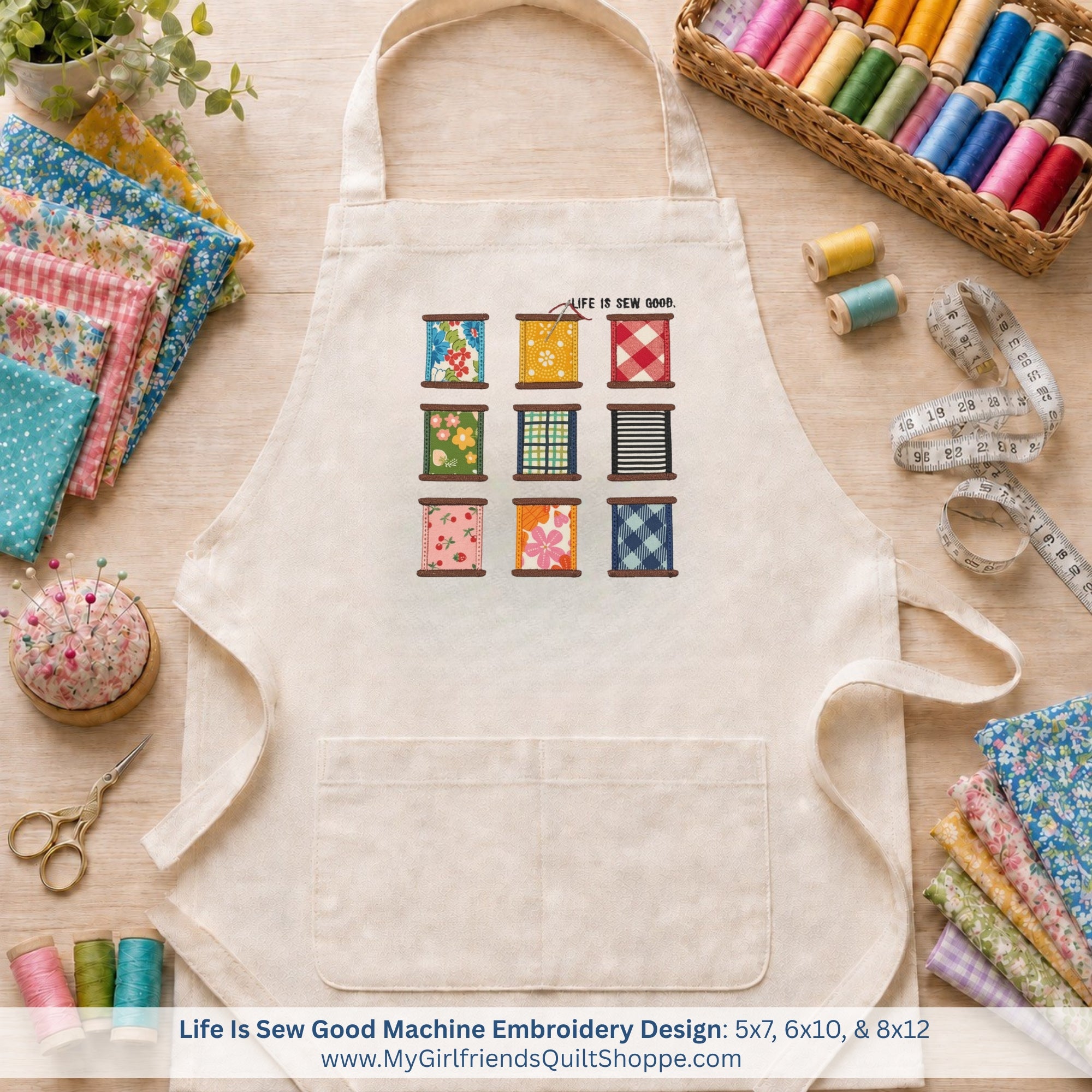 Beige apron with colorful embroidery design on a wooden table with sewing supplies.