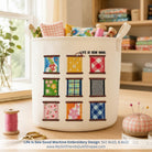 White laundry basket with colorful spool design and 'Life is Sew Good' text, placed on a wooden surface.