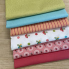 Stack of colorful fabric swatches on a wooden surface