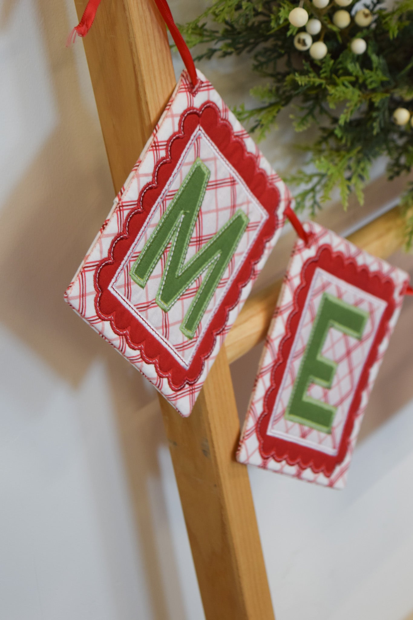 Decorative Christmas banner with 'M E' letters on a wooden stand.
