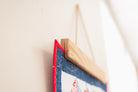 Close-up of a wooden picture frame with a red border on a light background 18" wall hanger