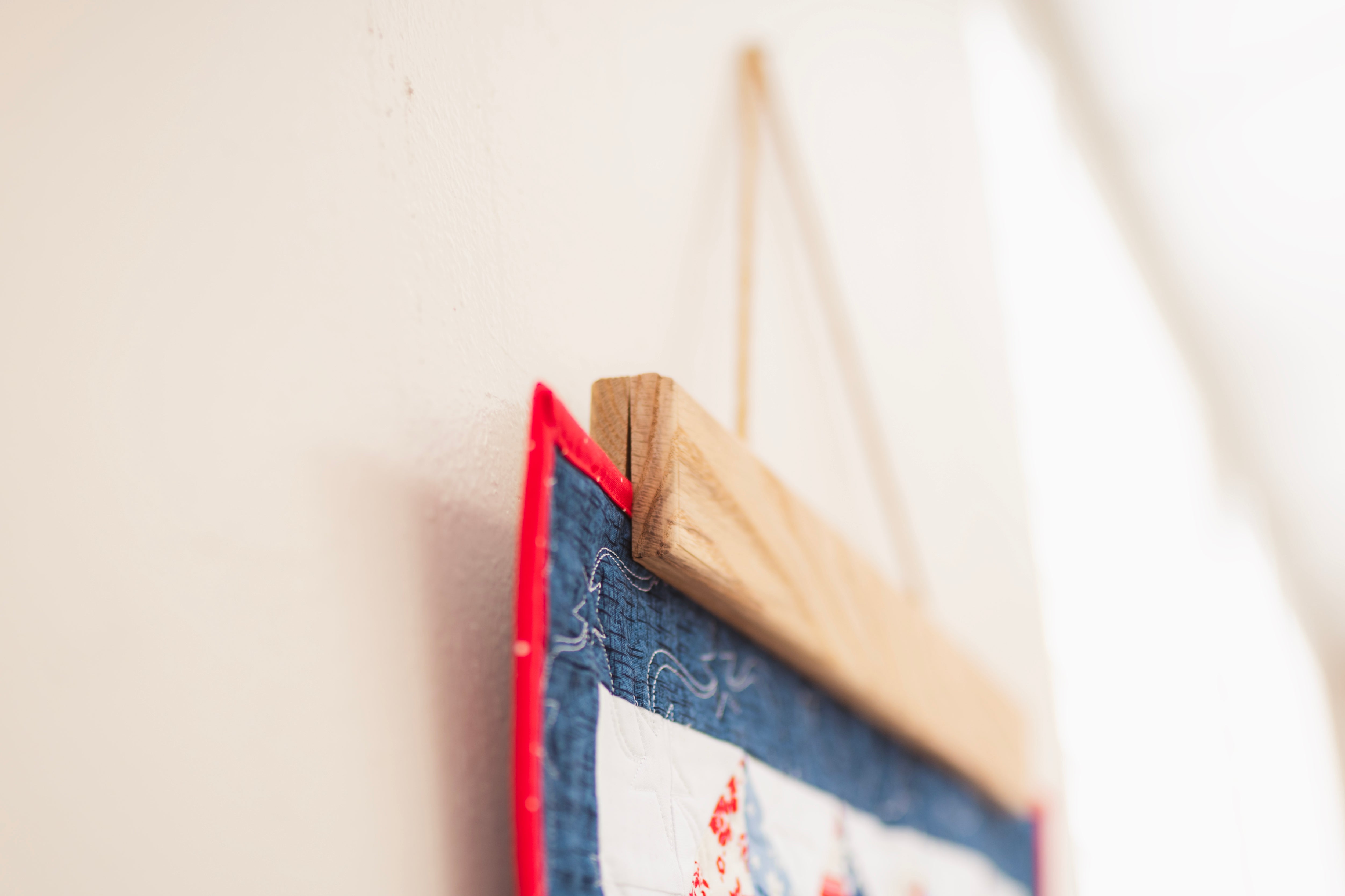 Close-up of a wooden picture frame with a red border on a light background 18" wall hanger