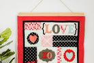 Decorative wall hanging with 'LOVE' and heart designs on a red background. 36" wall hanger