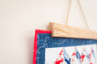 Fabric patch with red, white, and blue design hanging on a wooden frame against a light background 18" wall hanger