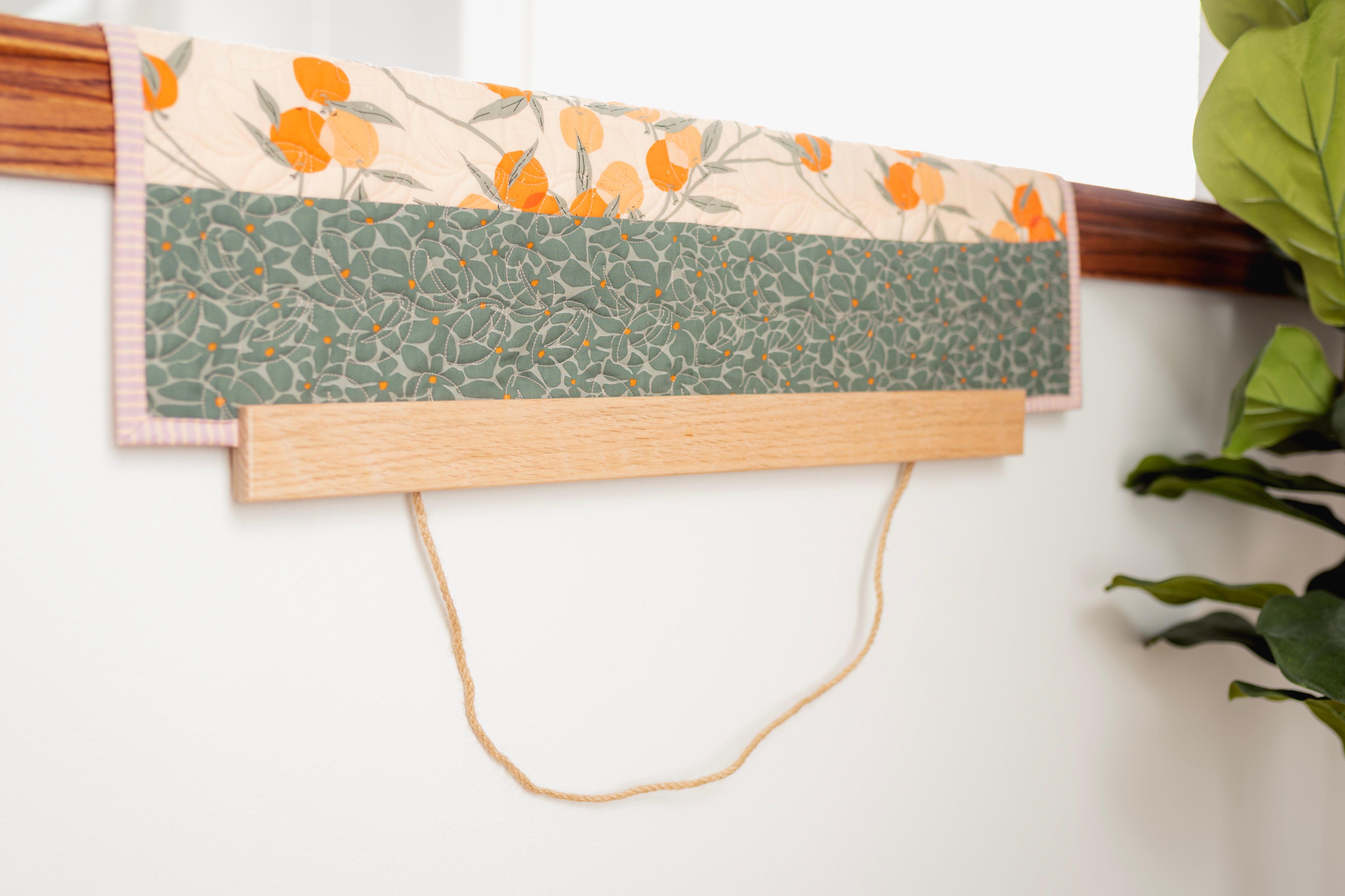 Fabric with floral and geometric patterns on a wooden board with a white background 24" wall hanger