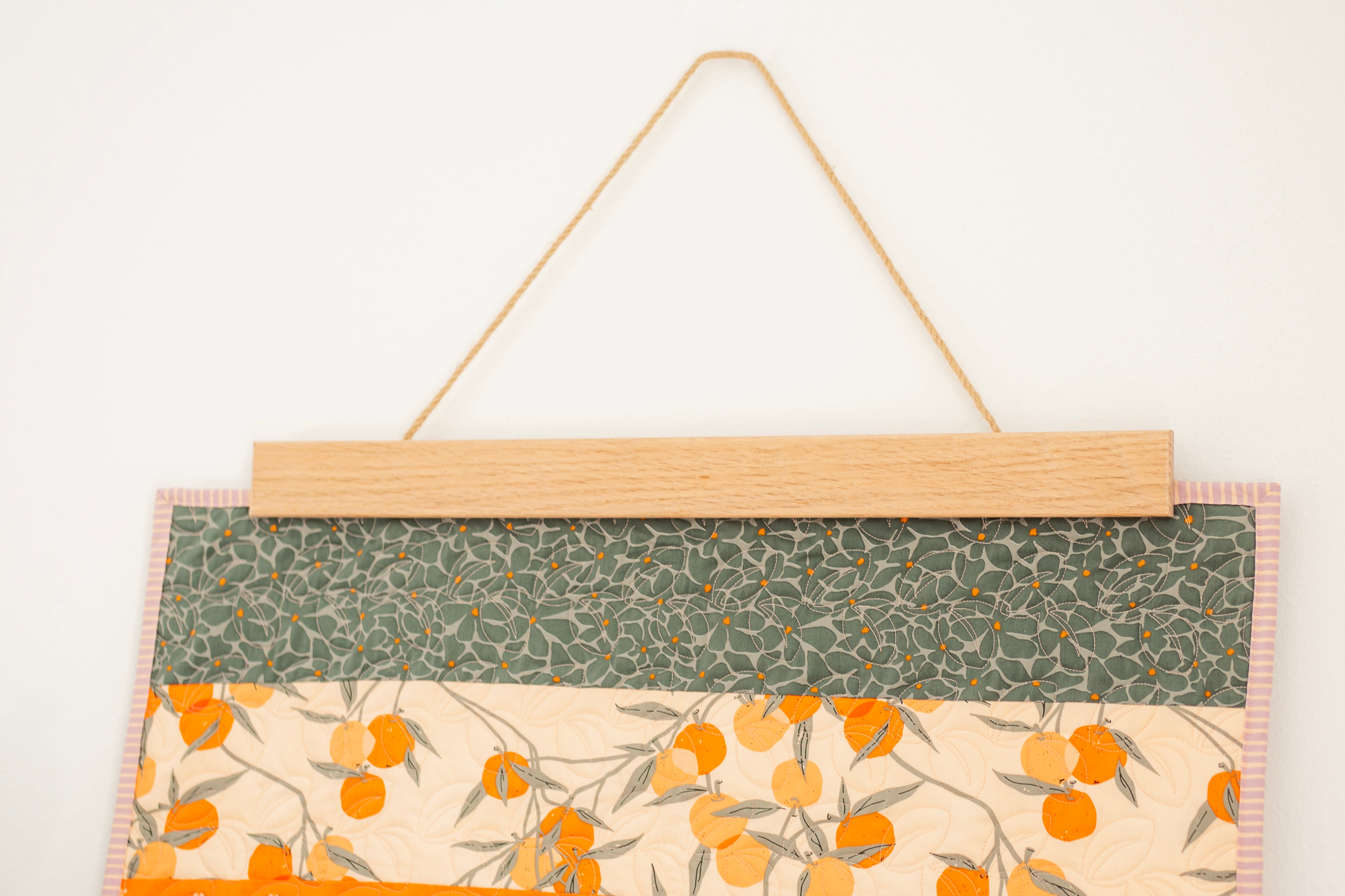 Fabric panel with floral pattern hanging on a white background 24" wall hanger