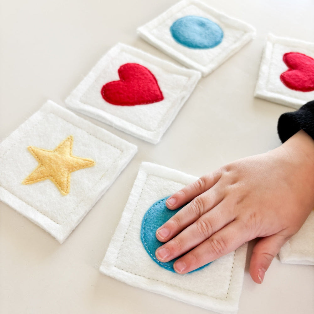 Set of colorful coasters with heart, star, and circle designs on a white surface.