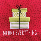 A close-up of a red fabric with a repeating polka dot pattern, featuring an applique design of stacked gift boxes with a black ribbon and the text 'MERRY EVERYTHING' in white embroidered letters.