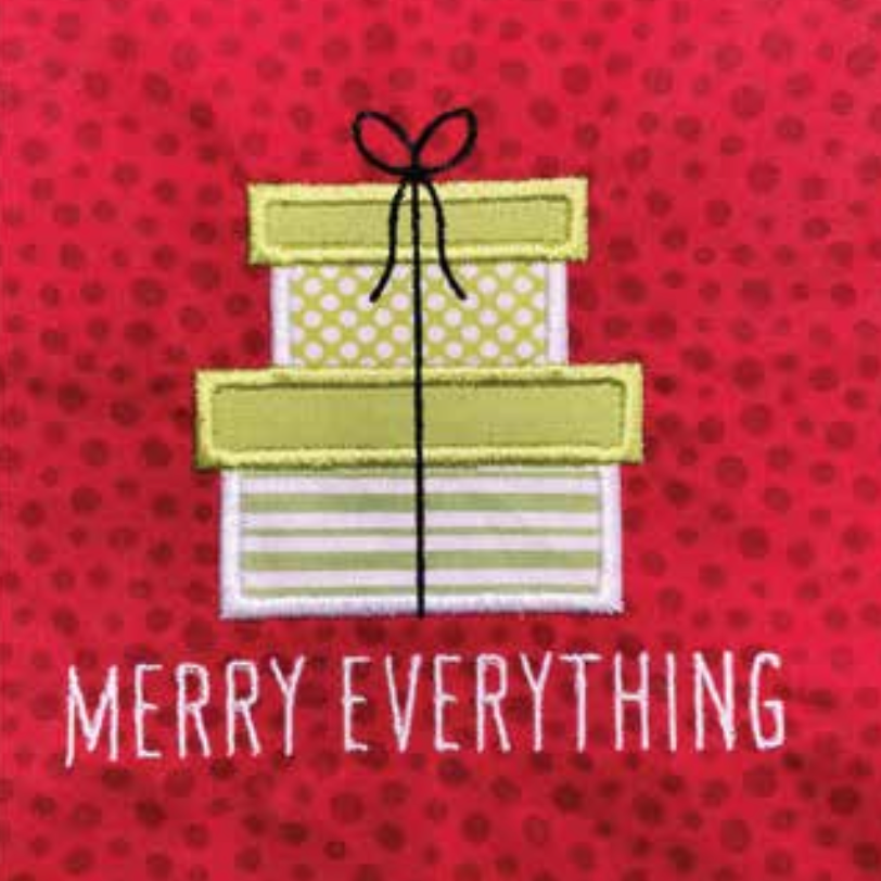 A close-up of a red fabric with a repeating polka dot pattern, featuring an applique design of stacked gift boxes with a black ribbon and the text 'MERRY EVERYTHING' in white embroidered letters.