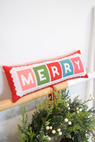 Decorative pillow with 'MERRY' in colorful letters on a white background