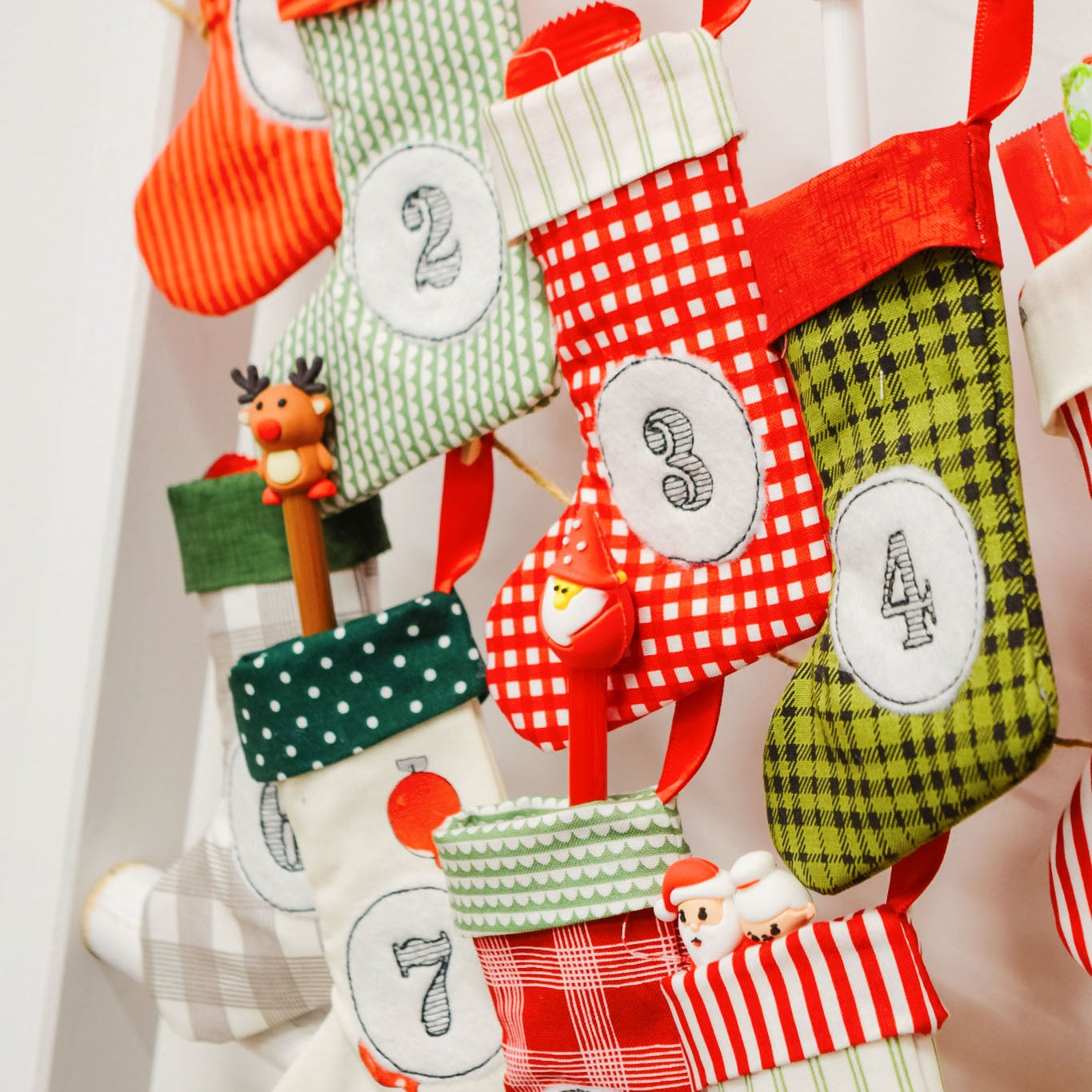 Colorful Christmas stockings with numbers hanging on a line against a white background