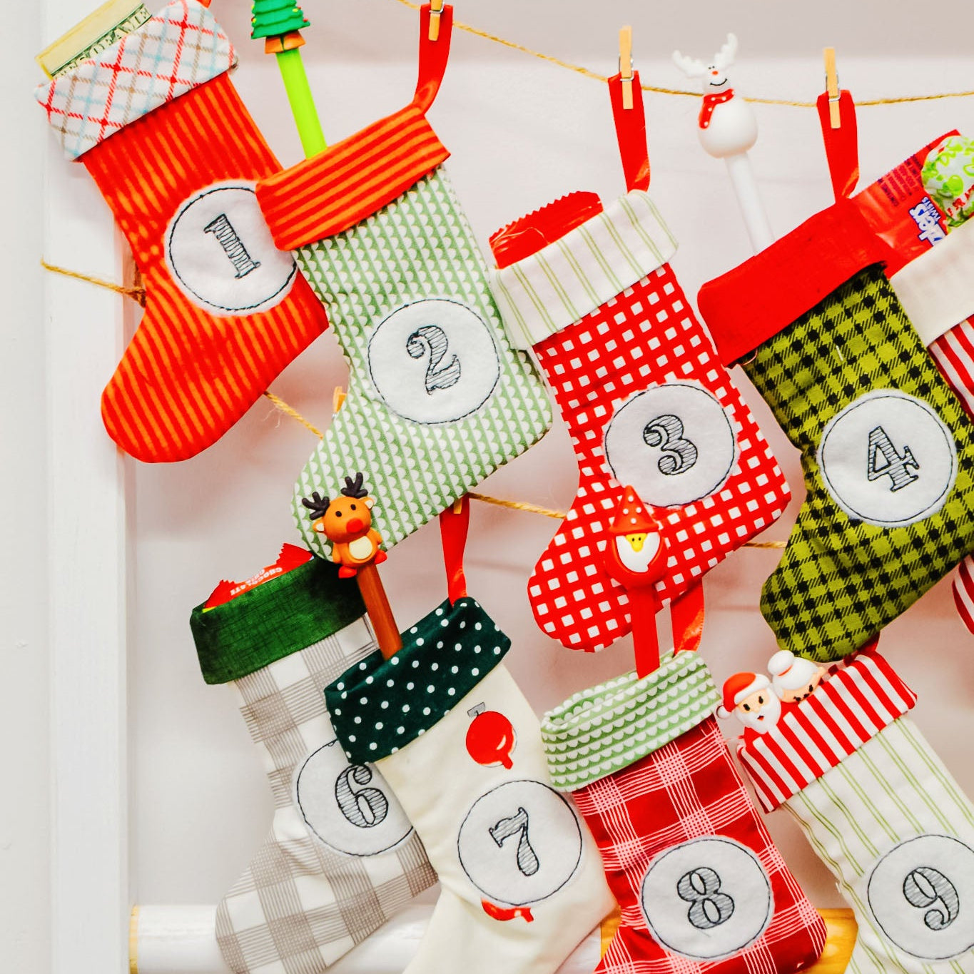 Colorful Christmas stockings with numbers hanging on a line.