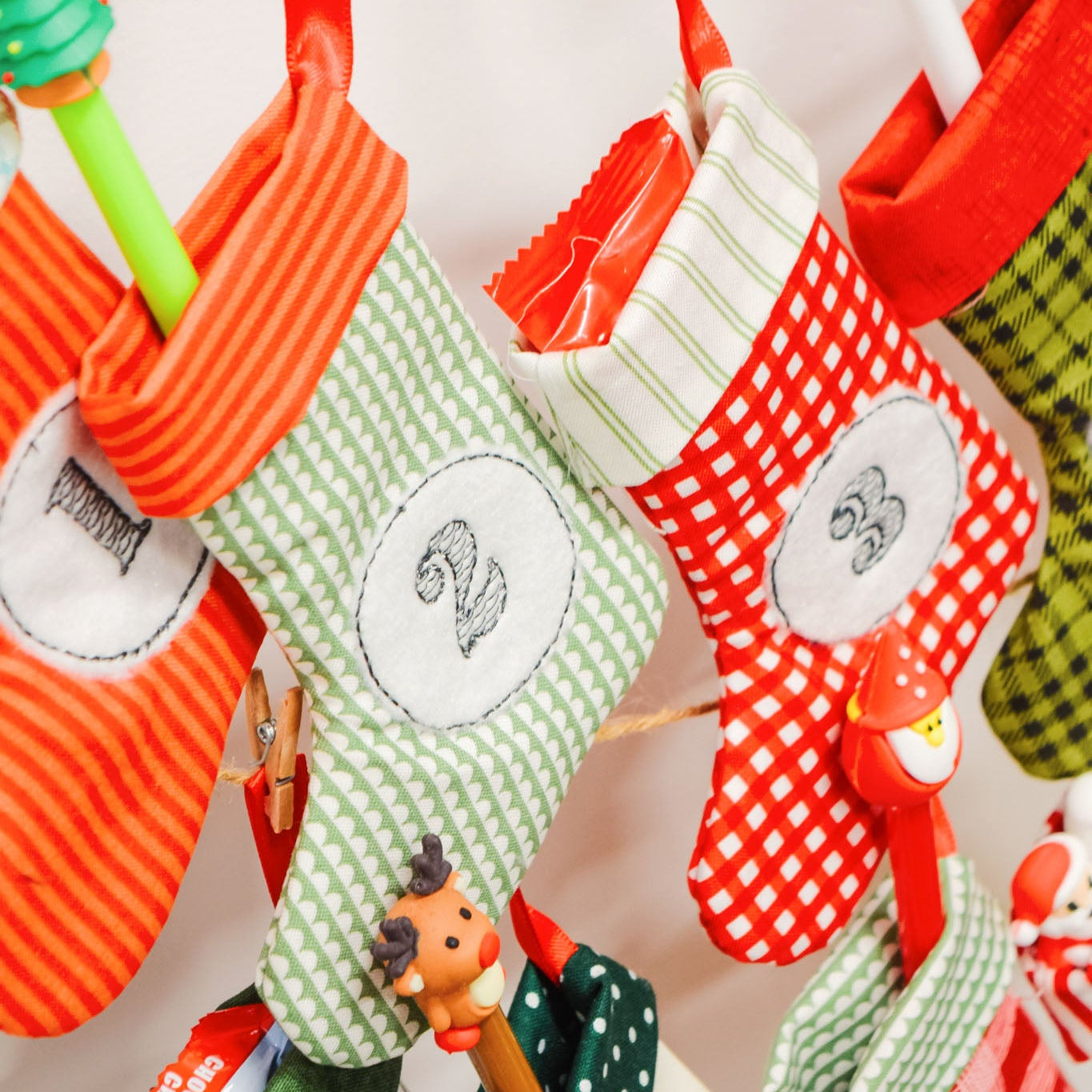 Colorful Christmas stockings hanging on a line with decorative elements.
