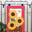 Decorative wall hangings with sunflowers and bees on a metal rack.