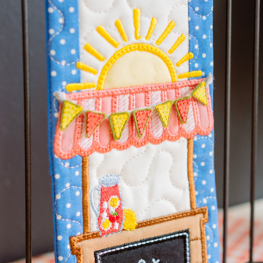 Decorative item with a hot dog stand and sun design on a blue polka dot background