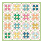 A quilt block pattern featuring a 4x4 grid of colorful floral starburst motifs on a white background with a light green border.