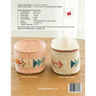 Back cover of a sewing pattern booklet showing two finished woven storage baskets/caddies on a wooden surface, with text listing fabric requirements, measurements, and a barcode at the bottom.