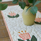Vase with plants on a tablecloth with floral design