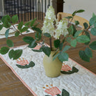 Vase with flowers on a tablecloth with floral design