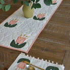 Floral table runner with a vase of flowers on a wooden table