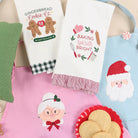 Collection of Christmas-themed kitchen towels and decorative items on a table.