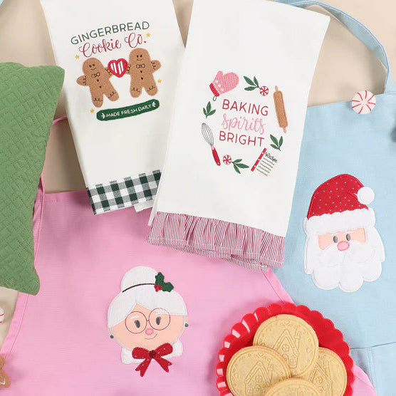 Collection of Christmas-themed kitchen towels and decorative items on a table.
