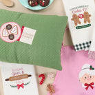 Collection of Christmas-themed kitchen towels and decorative items on a table.