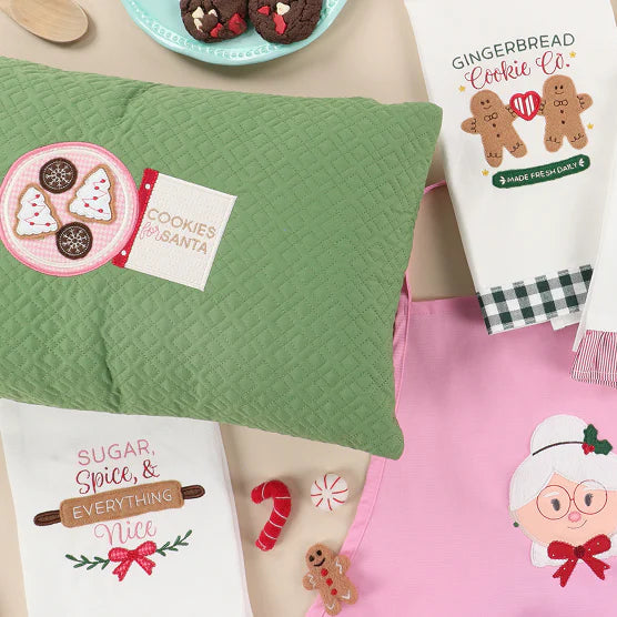 Collection of Christmas-themed kitchen towels and decorative items on a table.