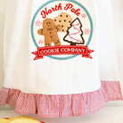Towel with 'North Pole Cookie Company' design featuring gingerbread men and a cookie cutter.