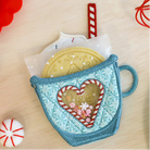 Decorative mug with heart-shaped cookie design on a wooden surface