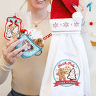 Person wearing a 'North Pole Cookie Company' apron with Christmas-themed decorations.