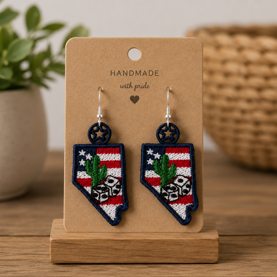 Handmade earrings on a wooden stand with a plant and woven basket in the background