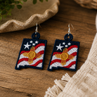 Pair of earrings with a design resembling the New Mexico state flag on a wooden surface.