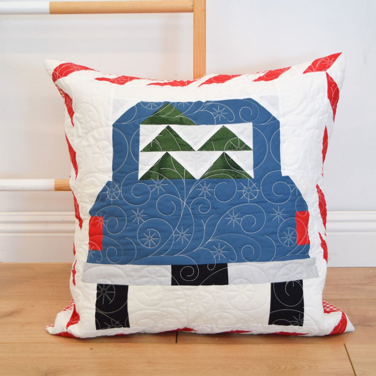 Quilted pillow with a truck design on a wooden floor