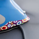 Colorful iron with a pattern on a gray surface