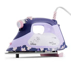 An Oliso steam iron with a purple and lavender color scheme, featuring a floral pattern on the base, a white handle grip, and pink accents on the steam button and cord.