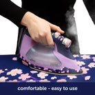 Person using a purple and gray iron on a floral ironing board with 'aliso' branding.