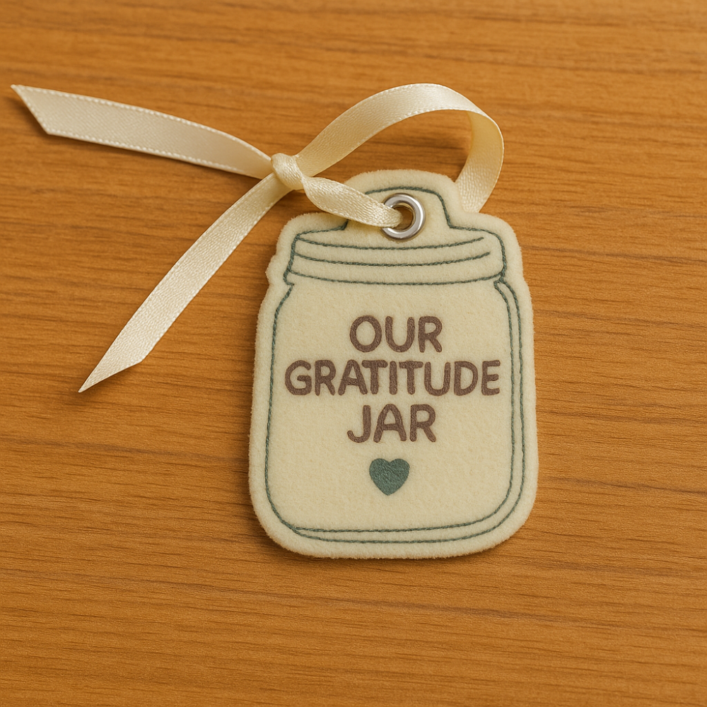 Fabric tag with 'Our Gratitude Jar' text on a wooden surface