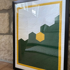 Framed geometric art piece leaning against a stone wall.