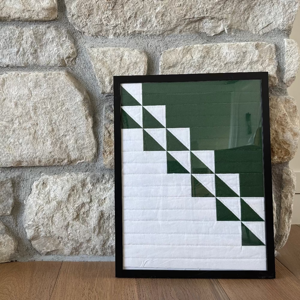 Framed geometric art piece on a stone wall