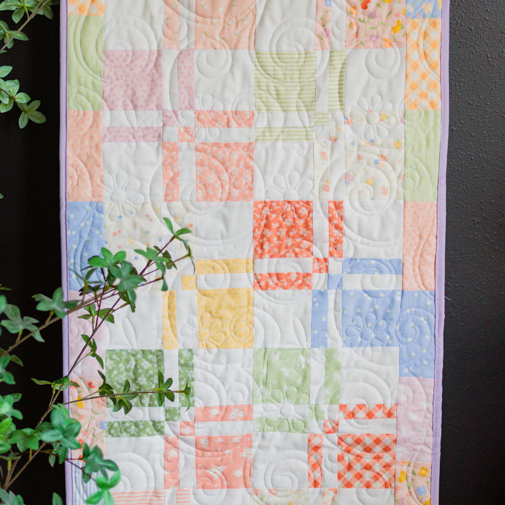 Colorful quilt with geometric pattern on a dark background