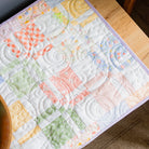 Quilt with Easter-themed decorations including eggs and carrots on a wooden surface.
