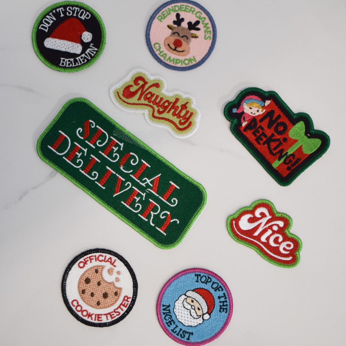 Set of Christmas-themed patches on a white marble surface