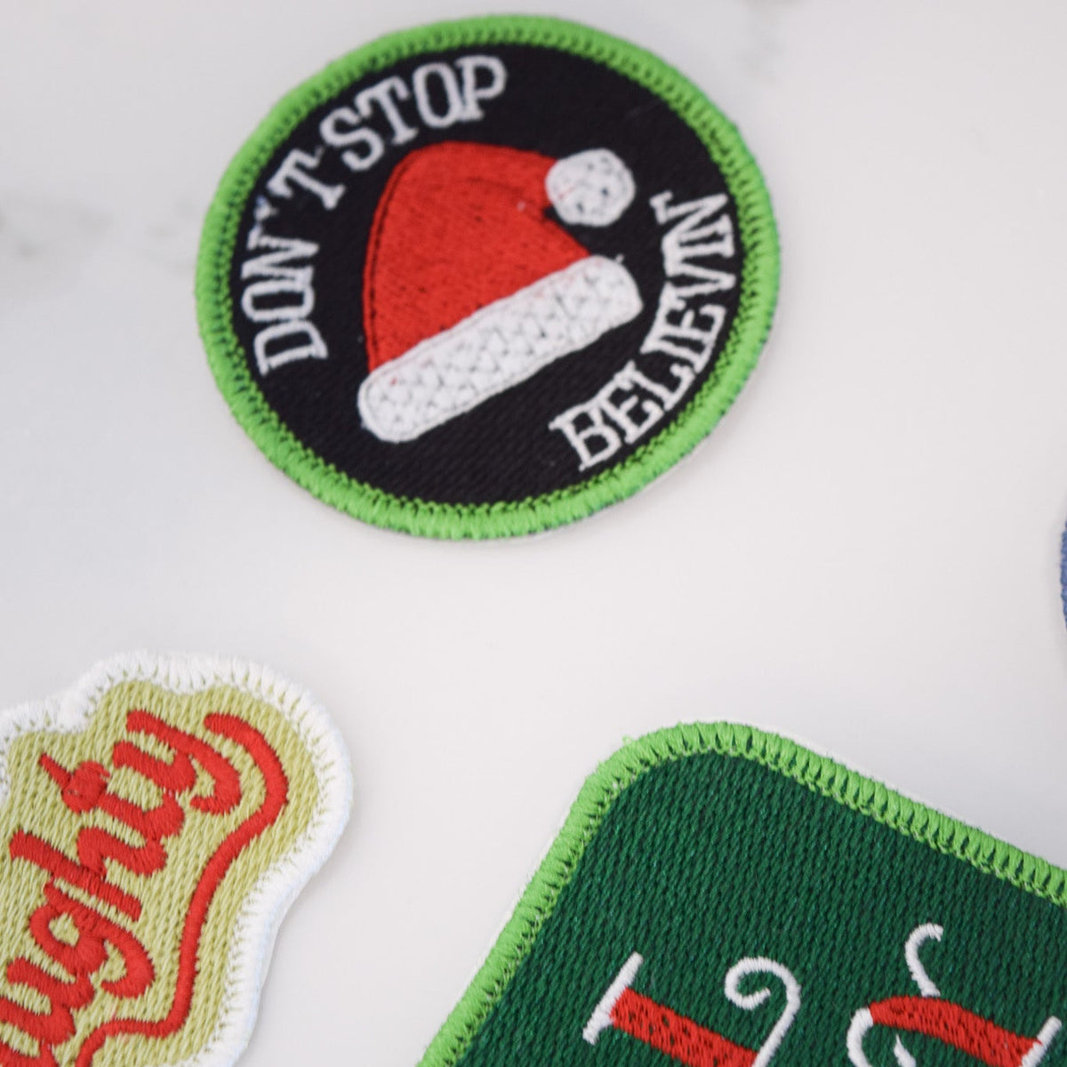 Three Christmas-themed patches on a white background