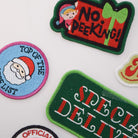 Collection of festive patches including 'No Peeking!', 'Top of the List', 'Official Cookie Tester', and 'Special Deliver'.