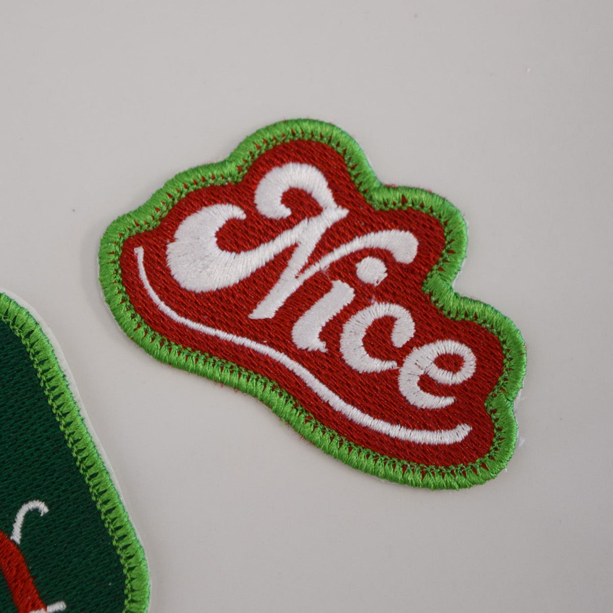Embroidered patch with 'Nice' text on a plain background
